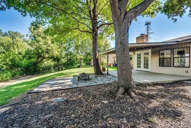 view of yard featuring french doors, a patio area, and a fire pit