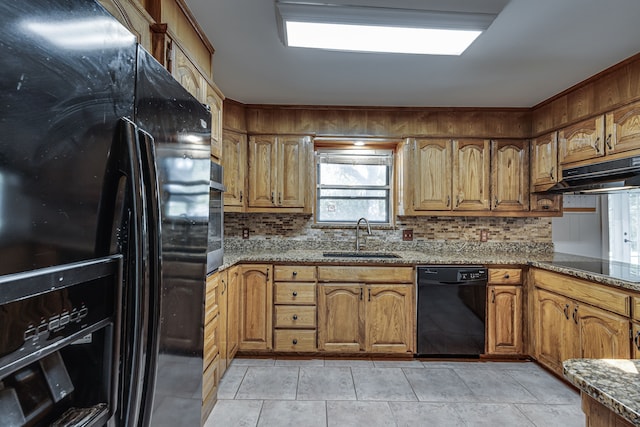 kitchen with tasteful backsplash, sink, black appliances, and stone countertops