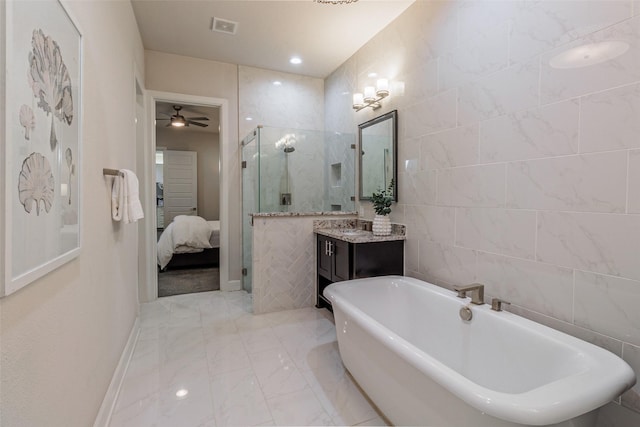 bathroom featuring ceiling fan, vanity, separate shower and tub, and tile walls