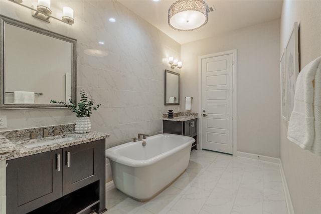 bathroom featuring a bath, vanity, and tile walls