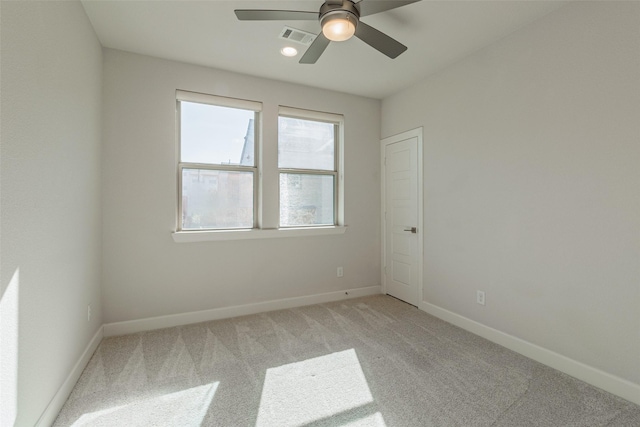 empty room featuring ceiling fan and carpet