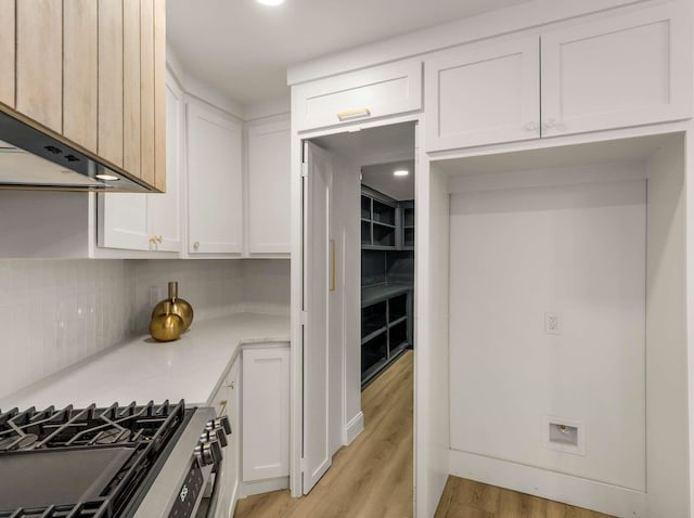 kitchen featuring custom range hood, white cabinets, and light wood-type flooring