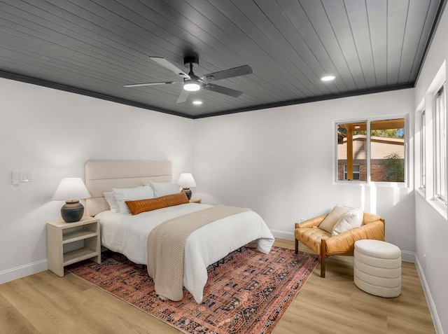 bedroom with crown molding, light hardwood / wood-style floors, and wooden ceiling