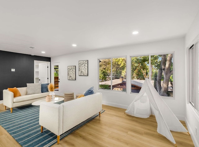 living room with plenty of natural light and light hardwood / wood-style flooring