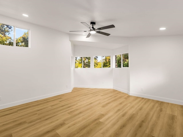 spare room featuring light hardwood / wood-style flooring, plenty of natural light, lofted ceiling, and ceiling fan