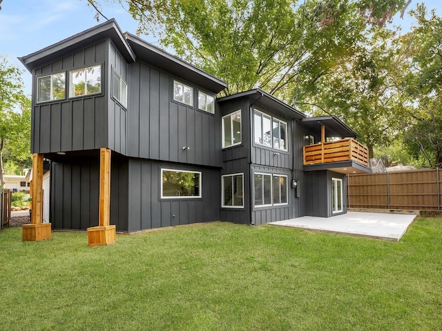 back of property with a balcony, a yard, and a patio area