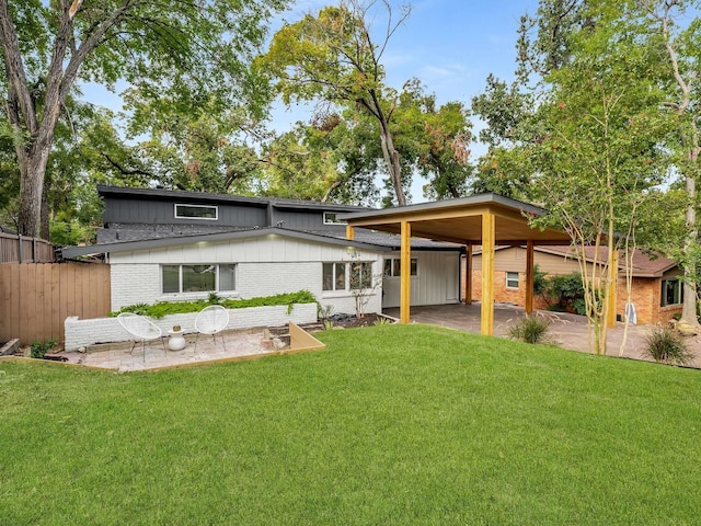 rear view of property featuring a yard and a patio