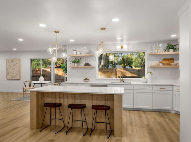 kitchen with white cabinetry, a breakfast bar, and decorative light fixtures