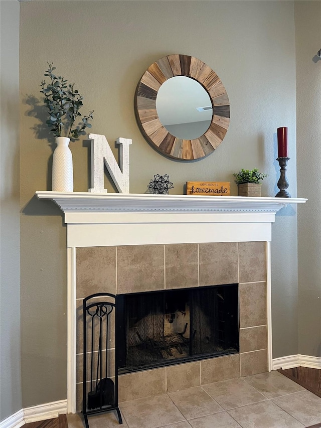 interior details featuring a tile fireplace