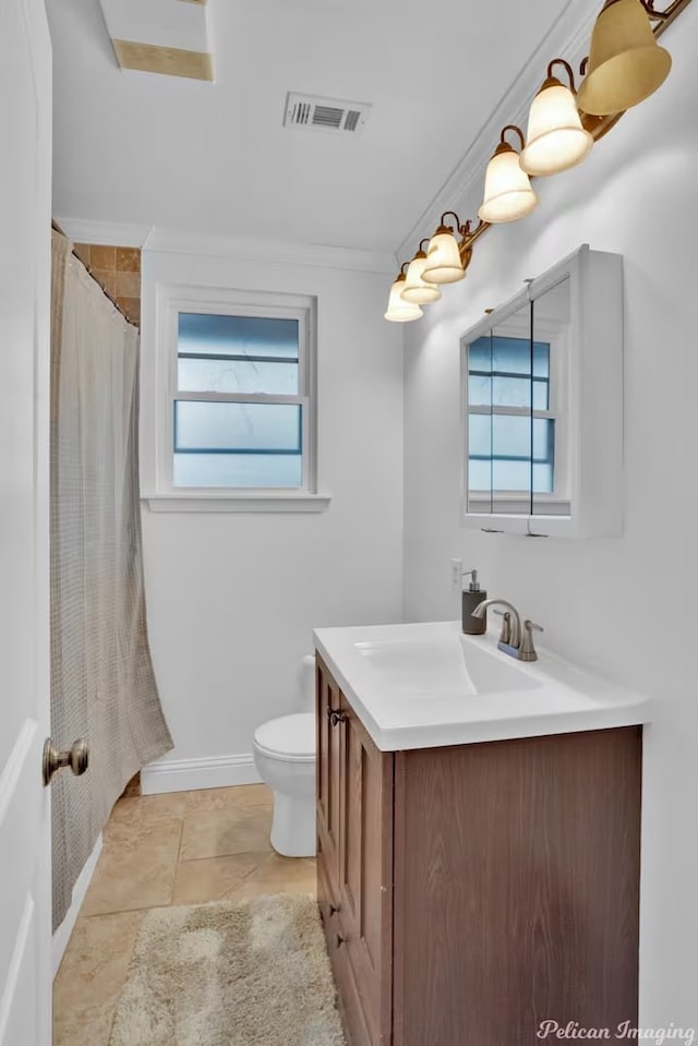 bathroom featuring vanity, crown molding, plenty of natural light, and toilet