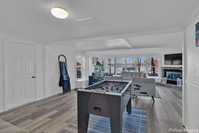 playroom with beam ceiling and light hardwood / wood-style floors