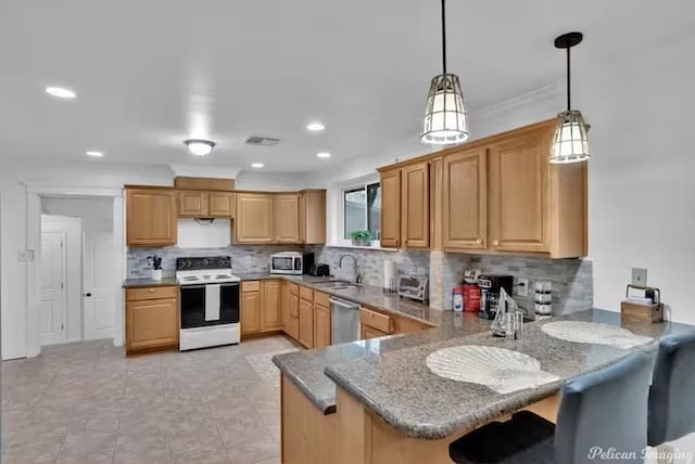 kitchen featuring sink, a breakfast bar area, appliances with stainless steel finishes, kitchen peninsula, and pendant lighting