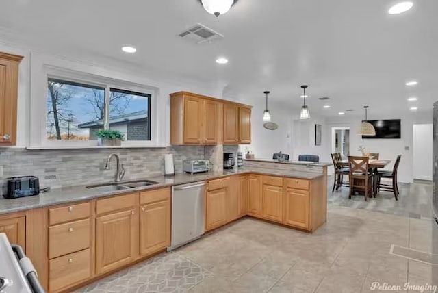 kitchen featuring pendant lighting, sink, decorative backsplash, stainless steel dishwasher, and kitchen peninsula