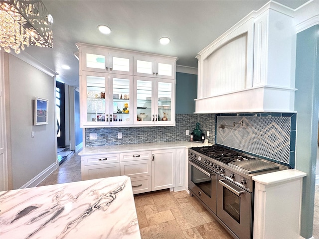 kitchen featuring white cabinetry, backsplash, ornamental molding, double oven range, and custom range hood