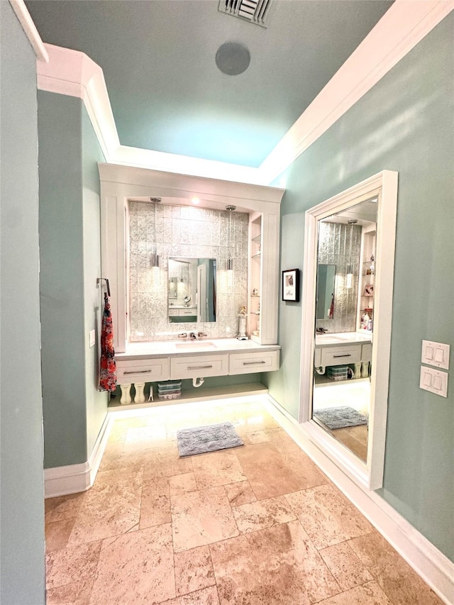 bathroom with ornamental molding and vanity