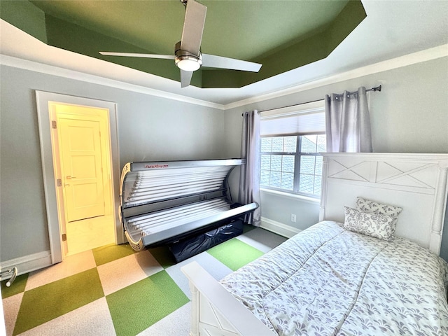 bedroom with a tray ceiling, ornamental molding, and ceiling fan