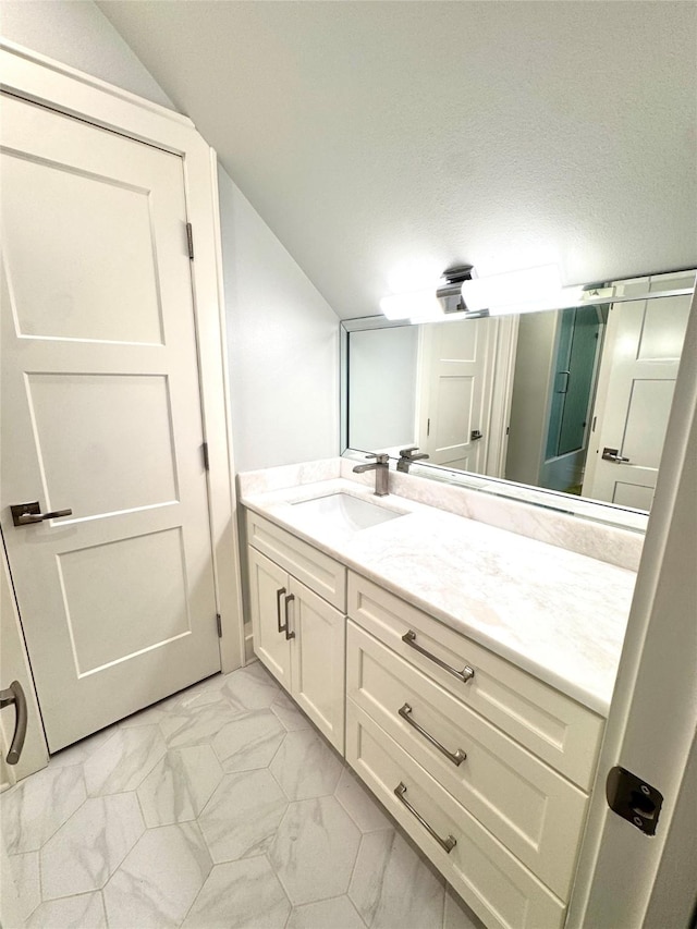 bathroom with vanity and vaulted ceiling