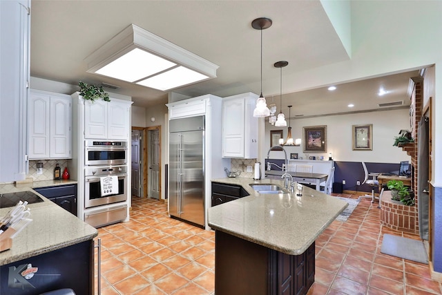 kitchen featuring sink, white cabinets, hanging light fixtures, kitchen peninsula, and stainless steel appliances