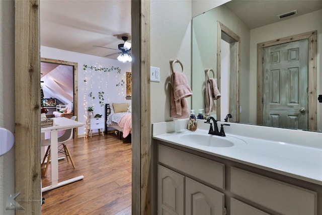 bathroom featuring hardwood / wood-style flooring, ceiling fan, and vanity