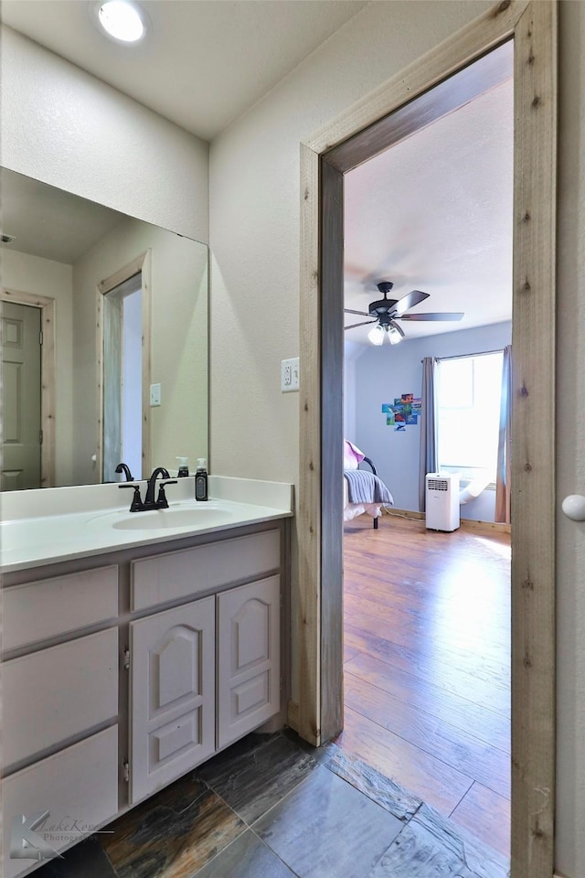 bathroom with ceiling fan, vanity, and wood-type flooring