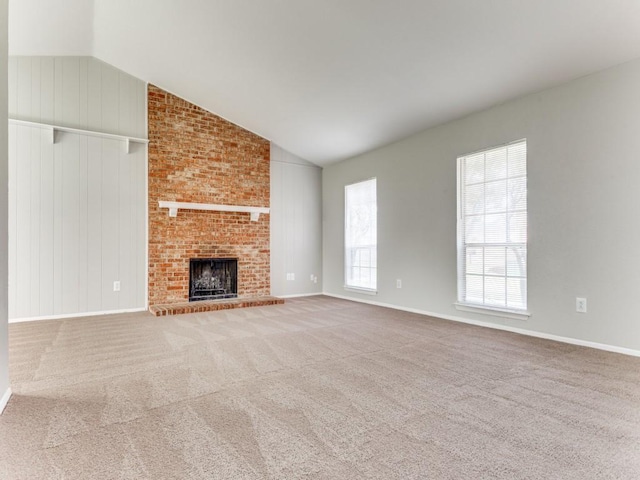 unfurnished living room featuring carpet flooring, a fireplace, and vaulted ceiling