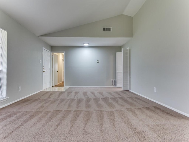 carpeted spare room with lofted ceiling