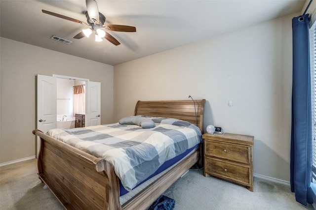 carpeted bedroom with ensuite bath and ceiling fan