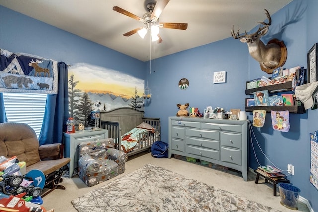 bedroom featuring ceiling fan and a crib