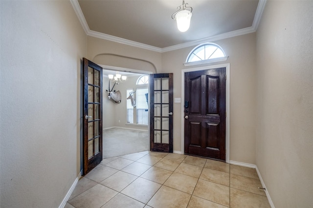 tiled entrance foyer featuring a notable chandelier, crown molding, and french doors