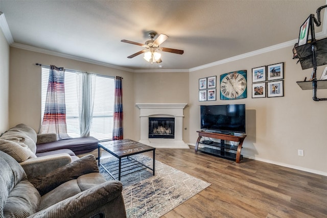 living room with hardwood / wood-style floors, ornamental molding, and ceiling fan