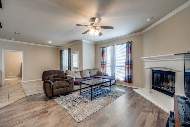 living room with hardwood / wood-style flooring, ornamental molding, and ceiling fan