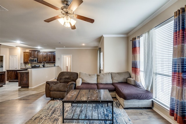 living room with crown molding, ceiling fan, and light hardwood / wood-style flooring