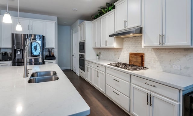 kitchen featuring dark wood-type flooring, appliances with stainless steel finishes, decorative light fixtures, and white cabinets