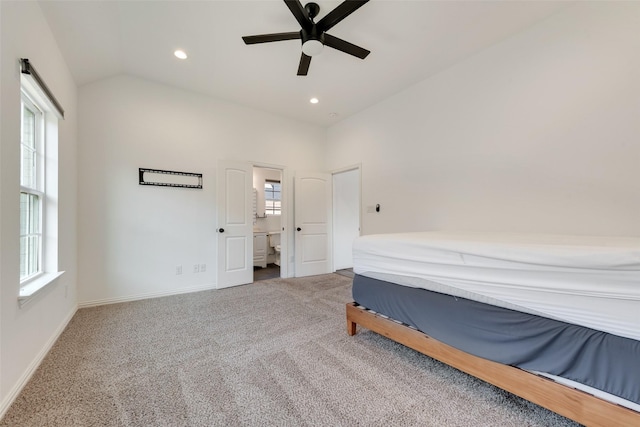 carpeted bedroom with ceiling fan, vaulted ceiling, and multiple windows