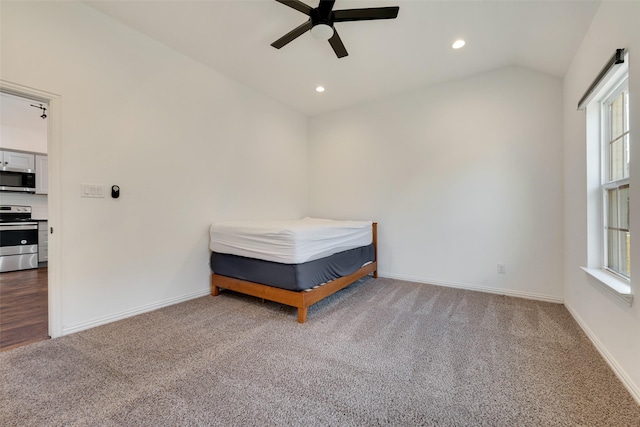 unfurnished bedroom featuring lofted ceiling, carpet floors, and ceiling fan