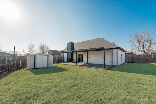 rear view of house with a yard, a patio, and a storage unit