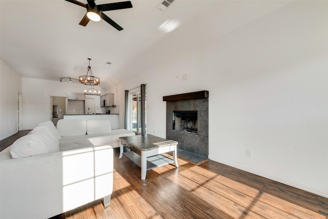 living room featuring wood-type flooring, ceiling fan with notable chandelier, and a fireplace