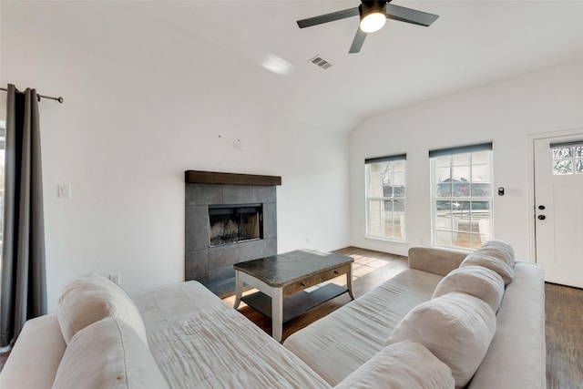 living room featuring hardwood / wood-style flooring, ceiling fan, a fireplace, and vaulted ceiling