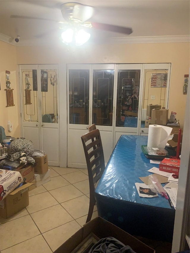 dining area with ceiling fan, ornamental molding, and light tile patterned floors