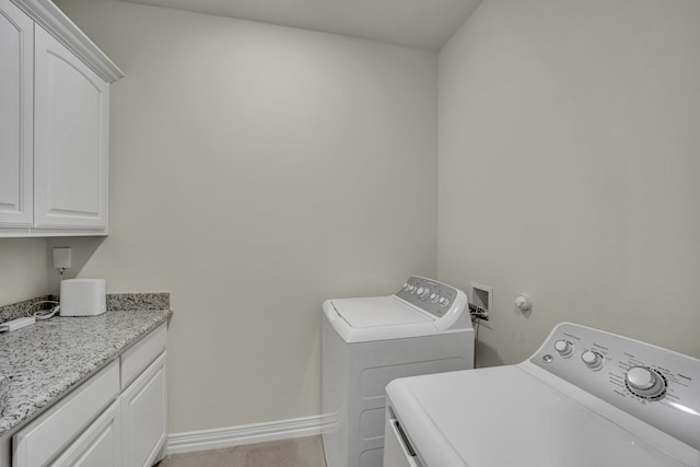 washroom featuring cabinets and washing machine and clothes dryer