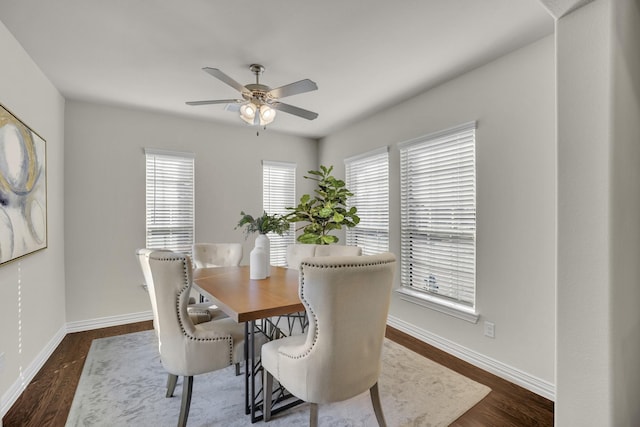 dining area with dark wood-type flooring and ceiling fan