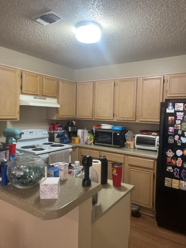 kitchen featuring black refrigerator, light brown cabinetry, and white range with electric cooktop