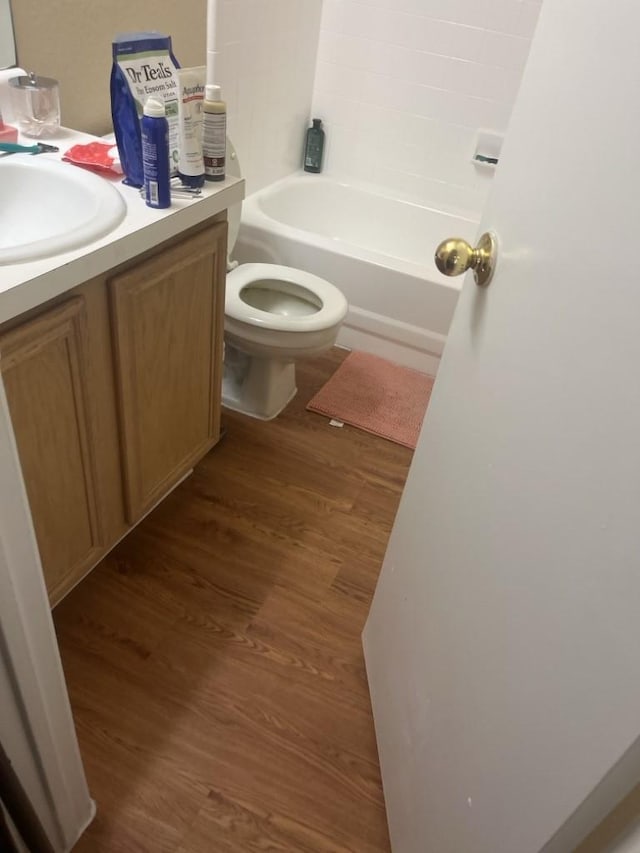 bathroom with wood-type flooring, vanity, and toilet