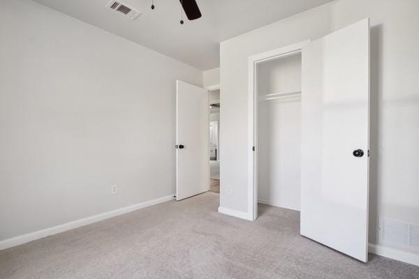 unfurnished bedroom featuring light colored carpet, a closet, and ceiling fan