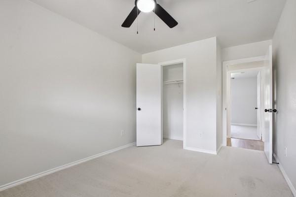 unfurnished bedroom featuring light colored carpet, a closet, and ceiling fan