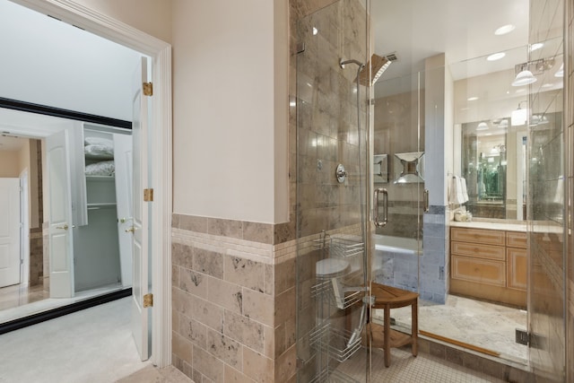 bathroom with vanity, tile walls, and an enclosed shower