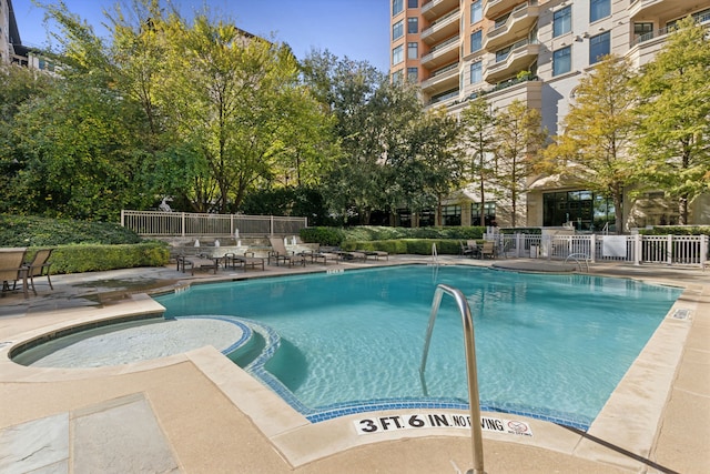 view of pool featuring a jacuzzi and a patio