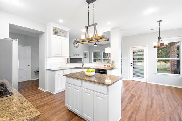 kitchen with light stone counters, black appliances, white cabinets, and light wood-type flooring