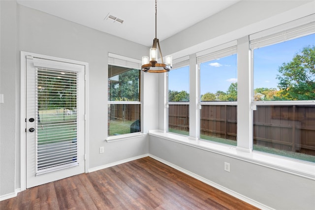 unfurnished sunroom featuring a chandelier