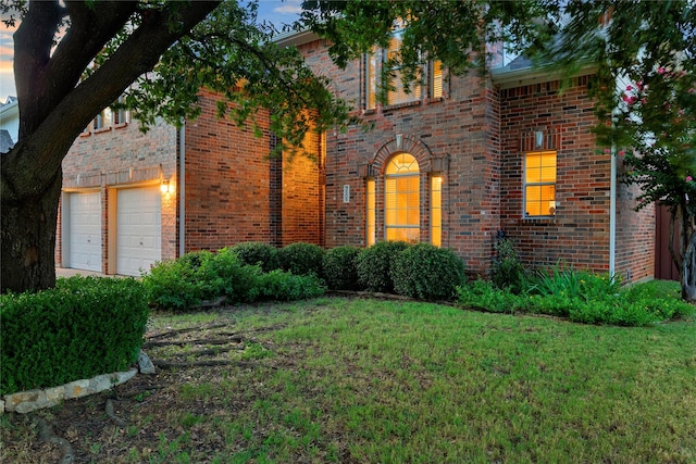 view of front facade with a garage and a lawn